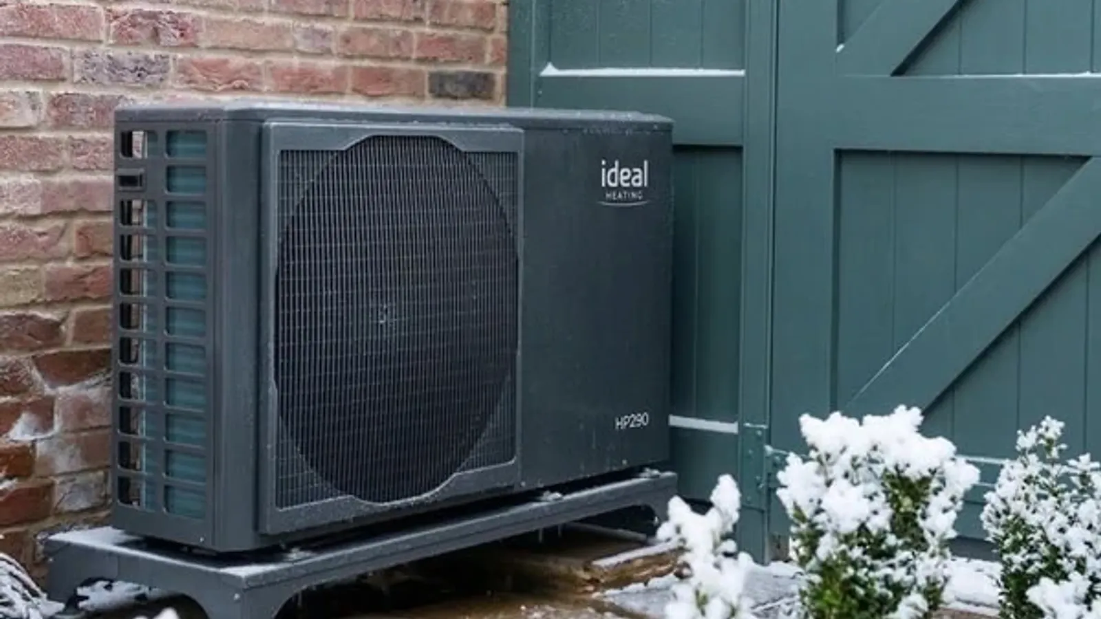 Ideal HP290 R290 air source heat pump installed against a UK home wall in snowy winter conditions