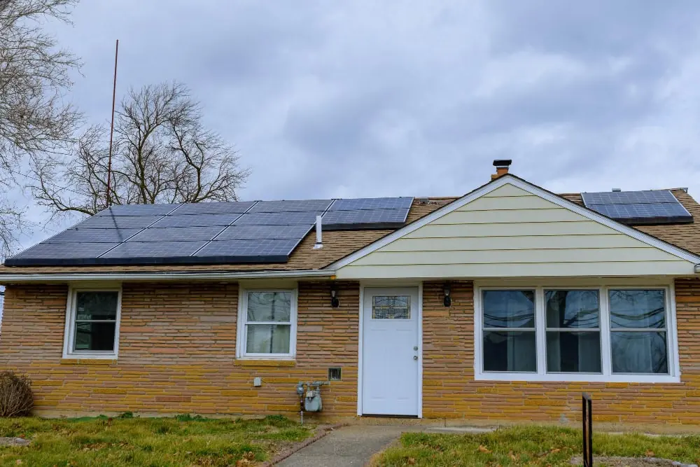 Single-storey UK bungalow with roof-mounted solar panels and an external gas meter box on the front wall