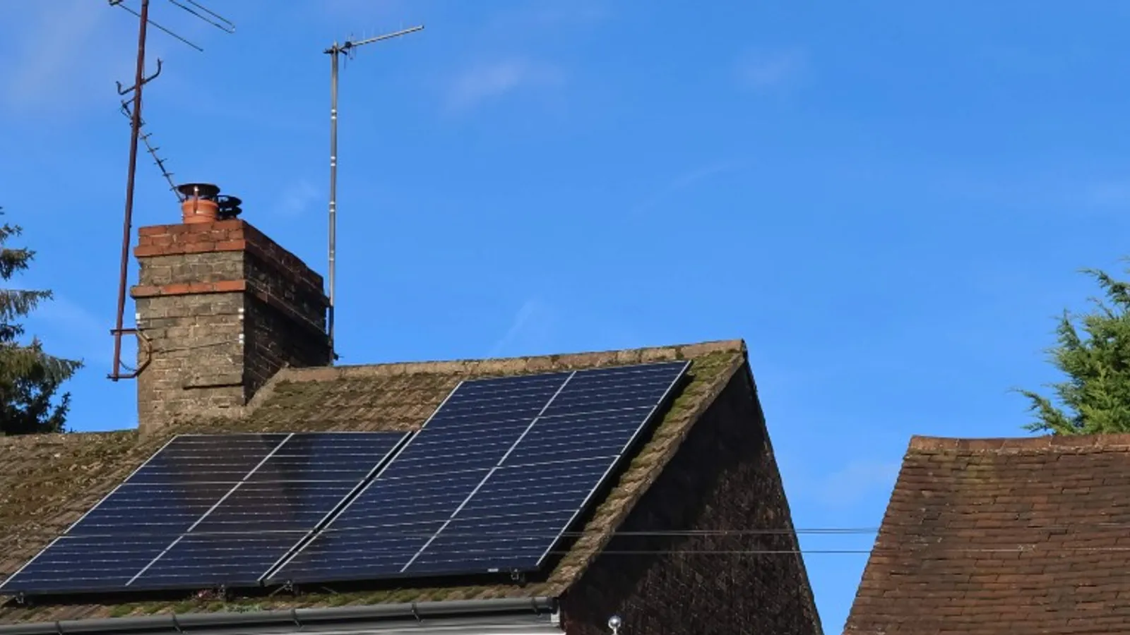 Solar panels on a UK home with a Union Jack flag, illustrating the Future Homes Standard solar mandate