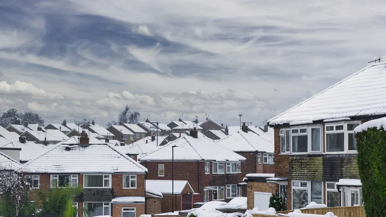 Snow-covered semi-detached houses under a cloudy winter sky in Harrogate, North Yorkshire