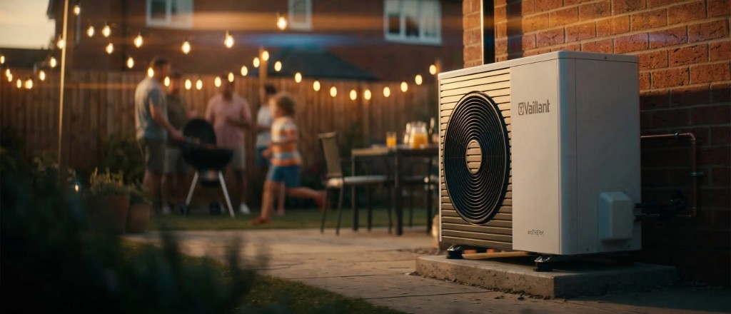 Family in their garden with a heat pump installed beside the house