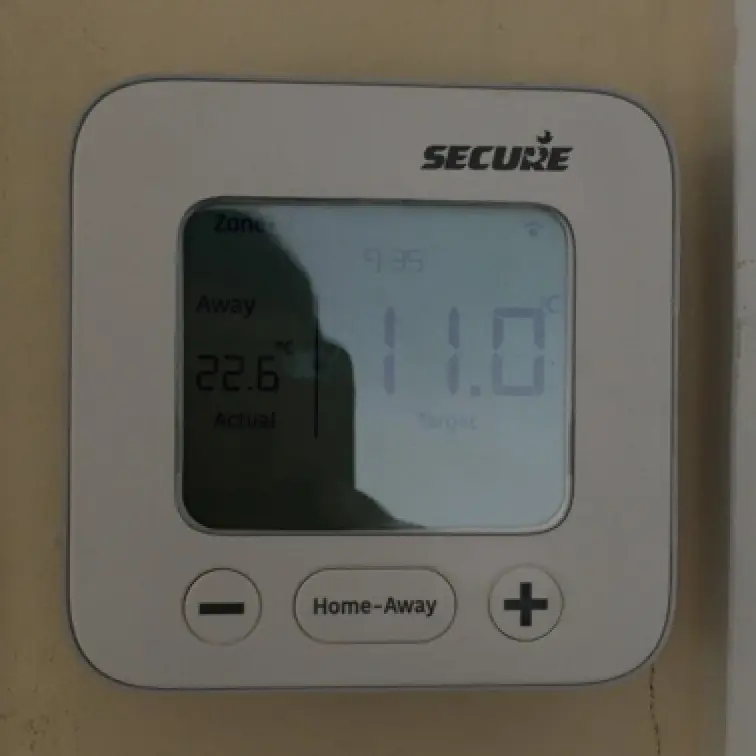 Wall-mounted digital room thermostat with home and away buttons