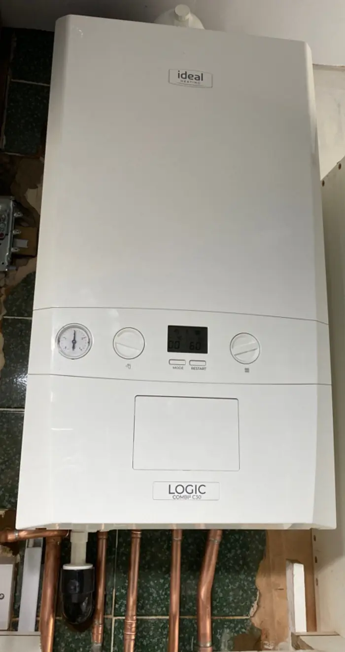 New white Ideal combi boiler in a cupboard, with fresh copper pipework below