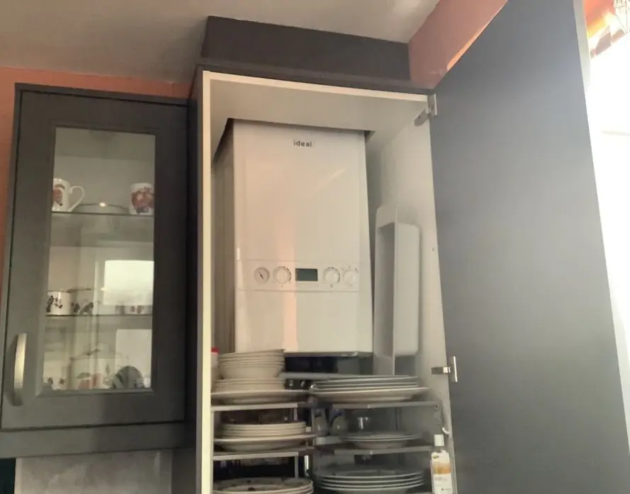 White Ideal boiler housed inside a tall kitchen wall cupboard