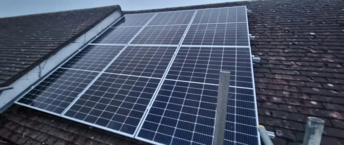 Solar panels on a dark tiled roof, with scaffold poles still in place