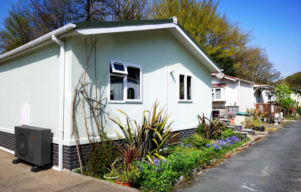 Trianco air source heat pump installed beside a residential park home on a landscaped park street