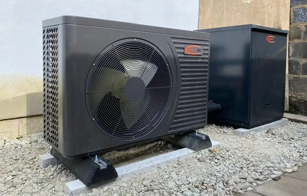 Trianco Activair outdoor heat pump and hot water cabinet installed side by side on a gravel plot