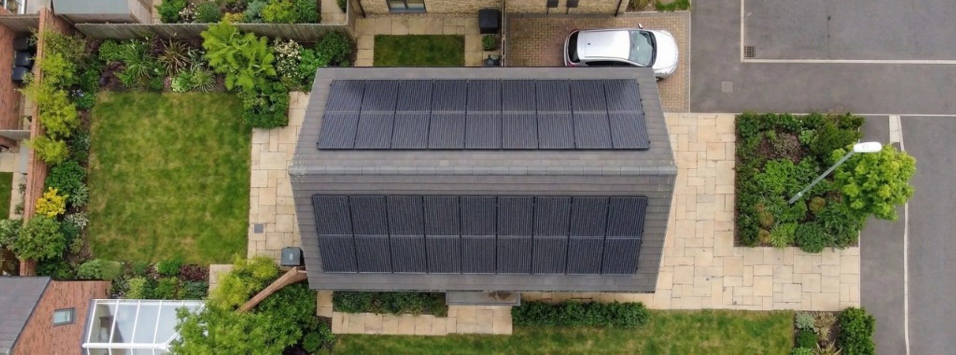 Aerial view of a UK home with all-black solar panels fitted to a south-facing roof